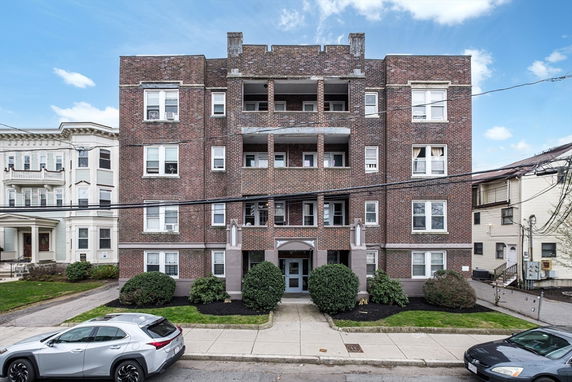 Front view of a multi-story brick apartment building.