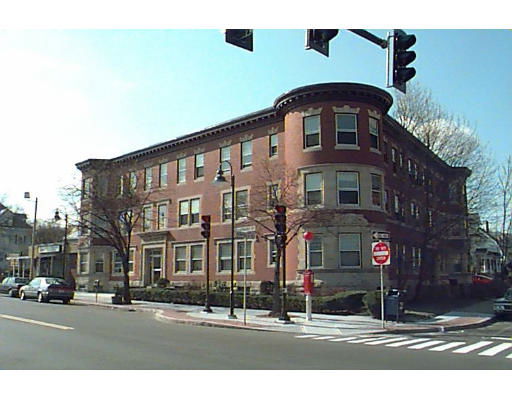 Front view of a multi-story apartment building at an intersection.