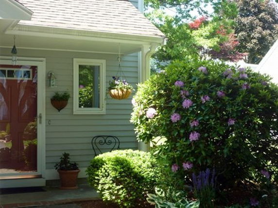 Front view of a house with a small porch and plants.