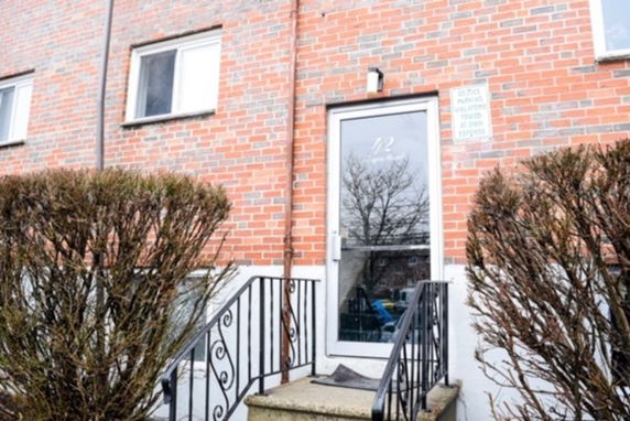 Front view of a brick building with a glass door entrance and steps.