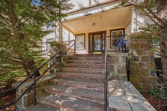 Front view of a house with a brick staircase and stone entryway.