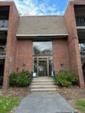 Front view of a brick apartment building with central entrance.