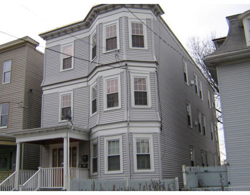 Front view of a multi-story house with bay windows.