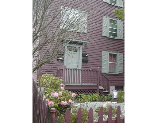 Front view of a multi-story house with purple siding and a porch.