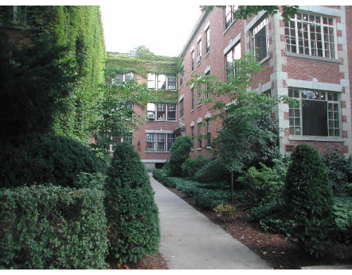 Front view of a brick building with large windows and ivy-covered walls.