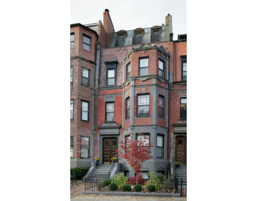 Front view of a multi-story brick townhouse with bay windows and a central entrance.