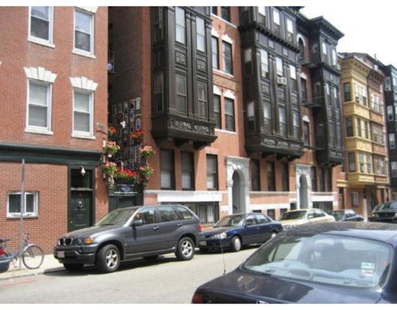 Front view of multi-story urban residential buildings with bay windows.
