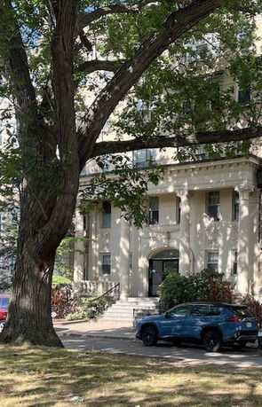 Front view of a multi-story building with a central entrance and large columns.