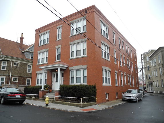 Front view of a three-story brick residential building.