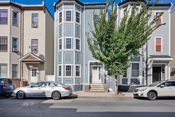 Front view of a multi-story row house with a bay window facade.