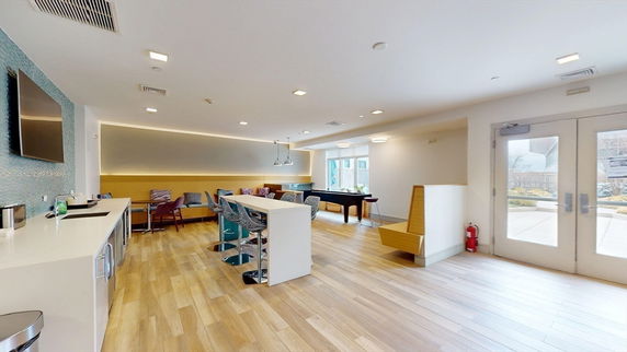 Interior view of a recreation room with a pool table and seating area.