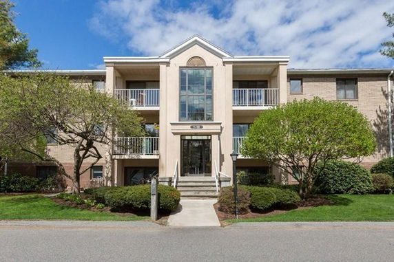 Front view of a multi-story apartment building with balconies.