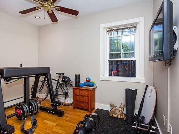 Indoor room equipped as a personal gym with weights and exercise equipment.