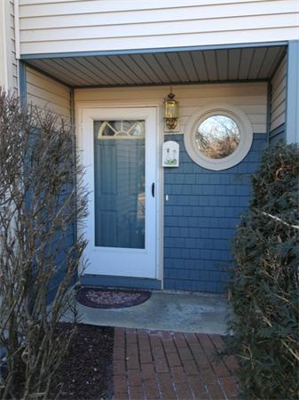 Close-up view of a house entrance with a white door and circular window.