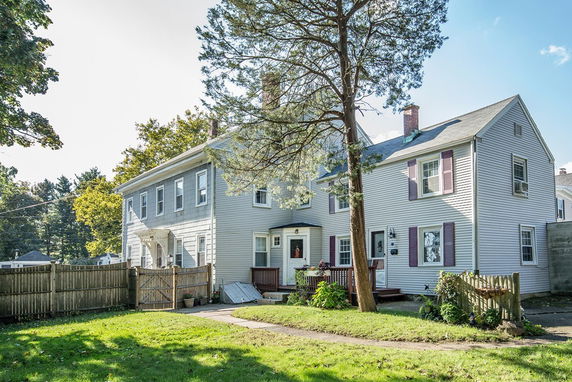 Front view of a two-story house with a fenced yard.