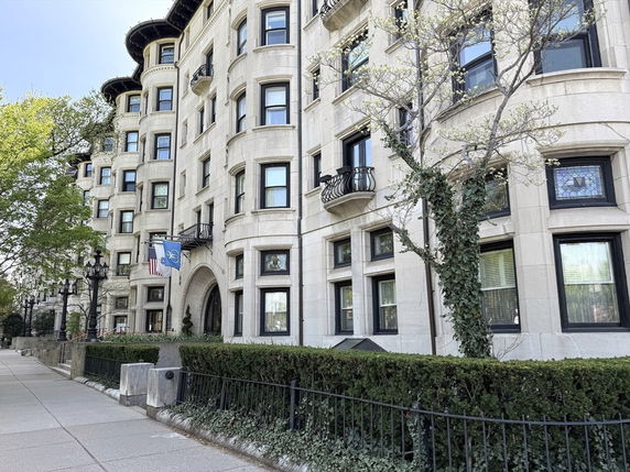 Front view of a multi-story building with rounded balconies and decorative windows.