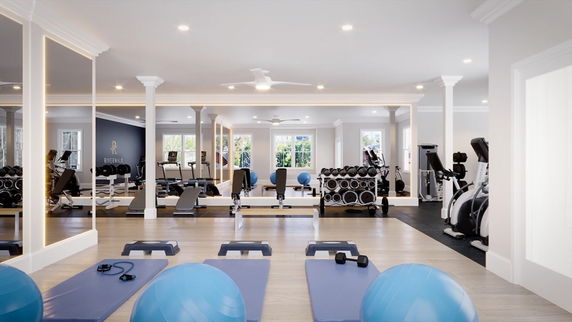 Interior view of a gym with fitness equipment and exercise mats.