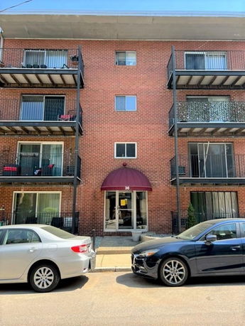 Front view of a multi-story brick building with balconies.