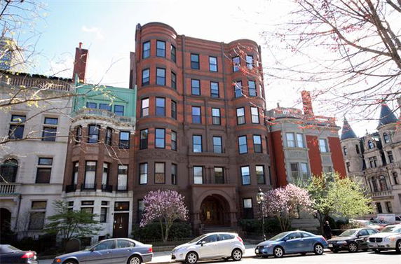 Front view of a multi-story brick building with large windows and decorative architectural details.