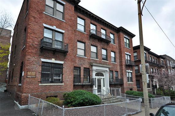 Front view of a three-story brick apartment building.