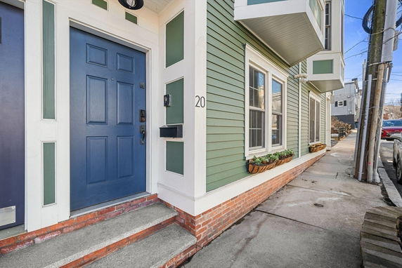 Front view of a house with green siding and a blue door.