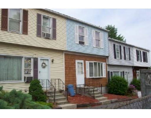 Front view of a row of two-story townhouses with varied siding colors.