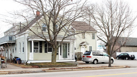 Front view of a two-story house with a porch and driveway.