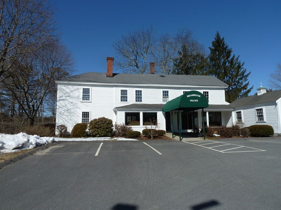 Front view of a two-story building with a green canopy entrance.