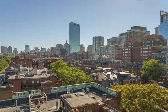 Panoramic view of urban skyline with various buildings and a tall skyscraper.