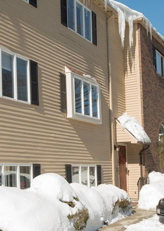 Front view of a multi-story house with icicles hanging from the roof.