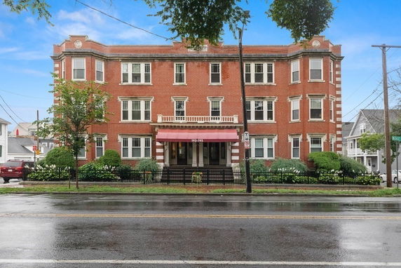 Front view of a three-story brick building with multiple windows and a central entrance.