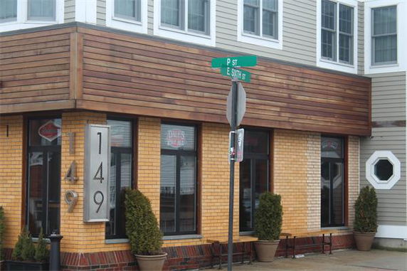 Front view of a two-story commercial building with large windows and a wooden facade.