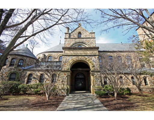 Front view of a stone building with arched entrance and gabled roof.