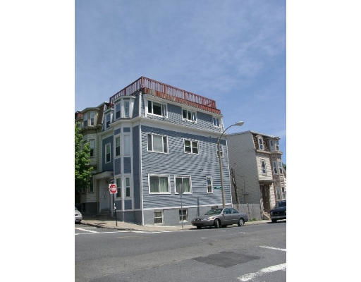 Front view of a multi-story building with blue siding.
