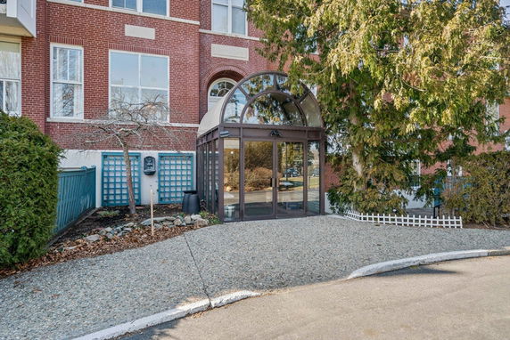 Front view of a building with a glass entrance and brick exterior.