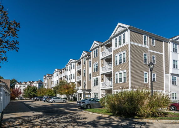 Front view of a multi-story apartment building with balconies.