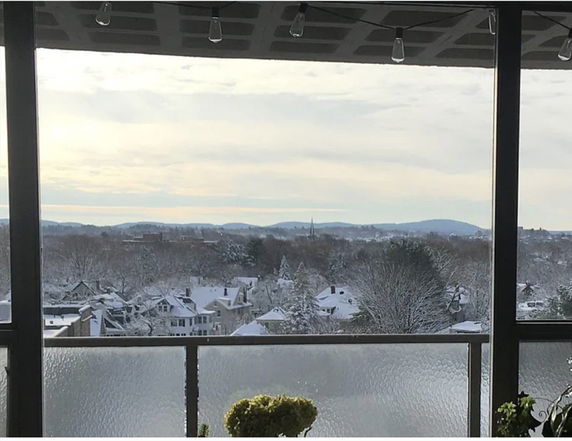 Wide angle view of snowy residential area seen from a balcony.