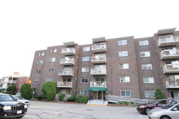 Front view of a multi-story apartment building with balconies.