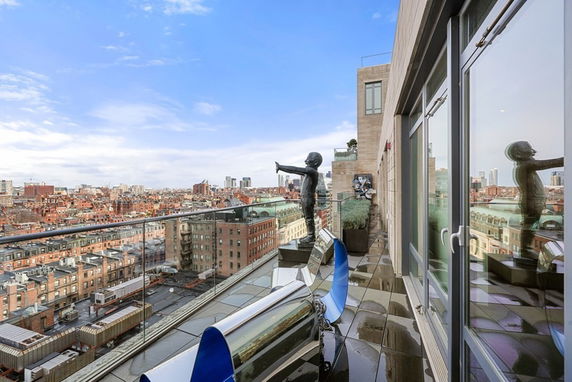 Panoramic view from a high-rise building balcony overlooking a cityscape.