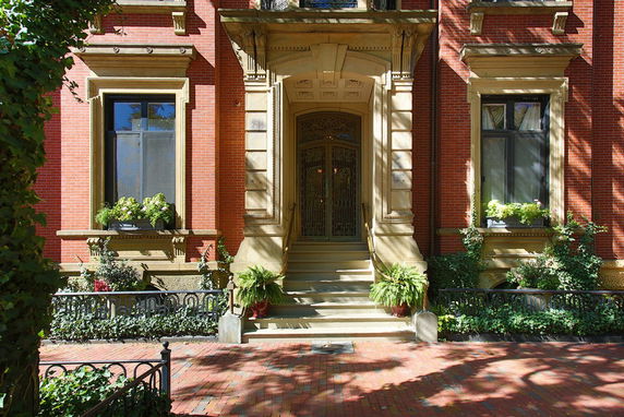 Front view of a brick building with ornate entrance and large windows.