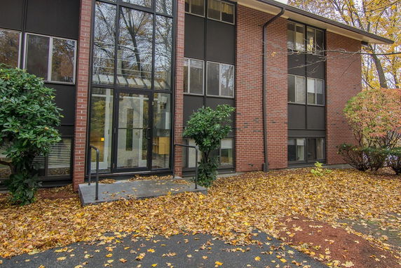 Front view of a brick building with large windows and a glass entrance.