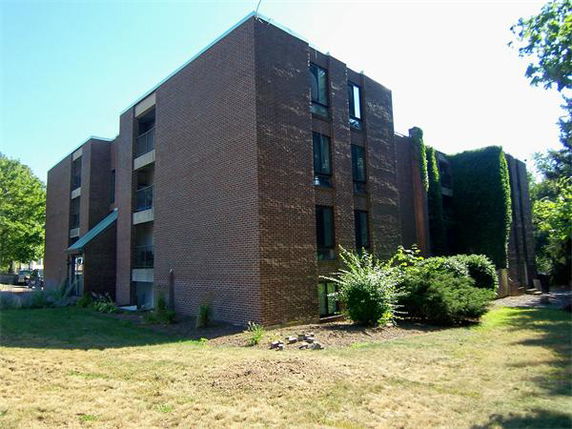 Exterior view of a multi-story brick apartment building with balconies.