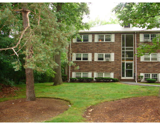Front view of a brick apartment building with multiple floors.