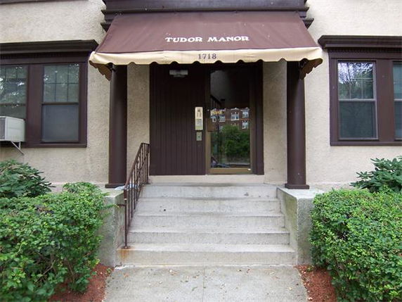 Front view of a building entrance with steps and an awning labeled 'Tudor Manor'.