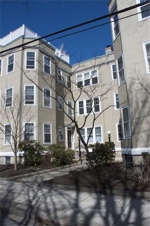 Front view of a multi-story apartment building with multiple windows.