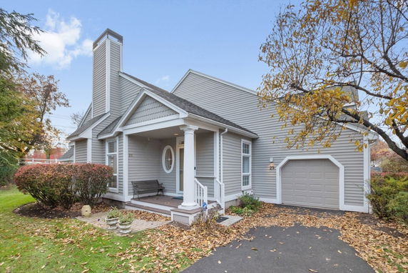 Front view of a single-story house with chimney and attached garage.