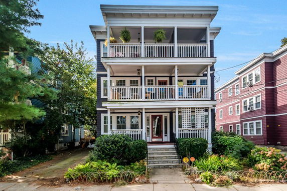 Front view of a three-story house with balconies on each floor.