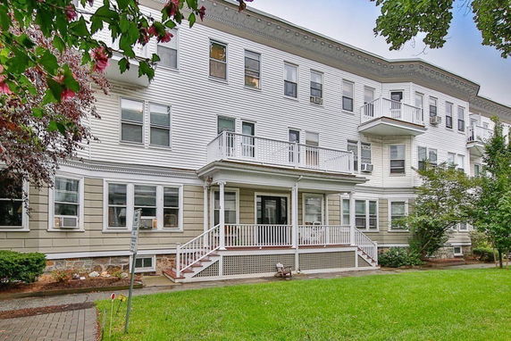 Front view of a multi-story apartment building with balconies.