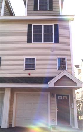 Front view of a multi-story house with a garage and entrance door.