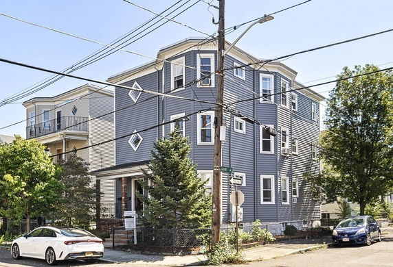 Front view of a multi-story house with blue siding and multiple windows.